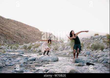 Belles femmes sauvages danser librement avec la rivière Désert. Banque D'Images