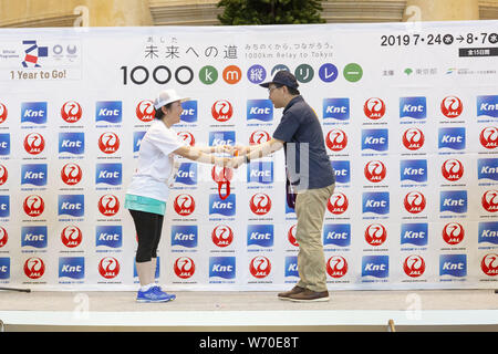 Fukushima, le Japon. 3e août 2019. Un coureur donne ''Le châssis de l'avenir (Demain)'' à l'organisateur au cours de la ''1000km relais à Tokyo 2019'' course à relais Spa Resort hawaïens. La ''Media Tour Tohoku : Cours de Fukushima'' organisé par la municipalité de Tokyo (TMG) met en valeur les efforts de récupération à Fukushima zone touchée par le grand séisme de l'Est du Japon 2011. Credit : Rodrigo Reyes Marin/ZUMA/Alamy Fil Live News Banque D'Images