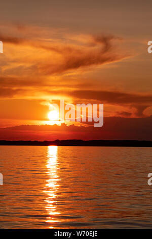 Coucher de soleil sur la digue de la rivière Amur à Khabarovsk. Le coucher de soleil sur l'horizon. Le remblai est éclairé par des lanternes. Banque D'Images