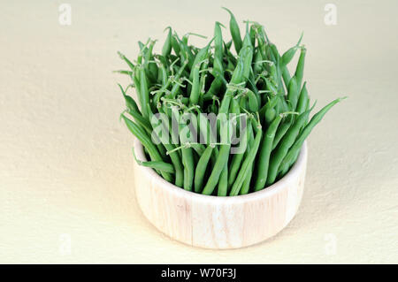 Haricots verts en cuvette ronde sur fond blanc Banque D'Images