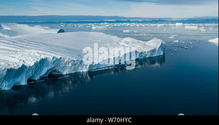 Le changement climatique et le réchauffement de l'iceberg géant - la fonte des glaciers à Ilulissat, au Groenland. Drone aérien d'arctic nature paysage célèbre pour être lourdement touchés par le réchauffement climatique. Bateau. Banque D'Images