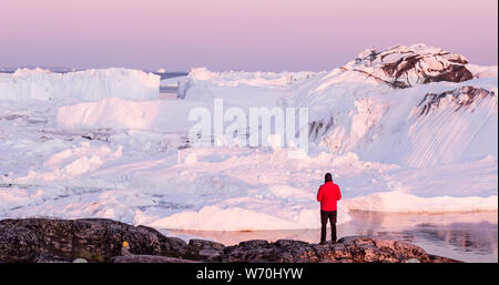 Dans l'Arctique voyage paysage nature d'icebergs du Groenland - homme touristiques explorer - office de personne regardant la vue étonnante du Groenland - drone aérien fjord glacé d'image. L'homme par l'état des glaces et des icebergs, Ilulissat. Banque D'Images