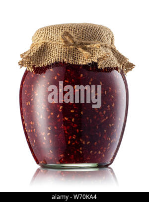 La confiture de framboises dans un bocal en verre recouvert de jute isolé sur fond blanc. Conserves de fruits maison Banque D'Images