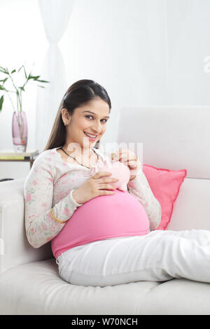 Pregnant woman saving money for her baby Stock Photo