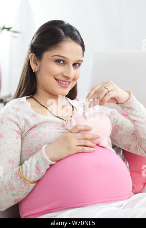 Pregnant woman saving money for her baby Stock Photo