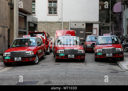 Les taxis urbains rouge ayant une pause à la fin de dead-end street à Wan Chai, Hong Kong Banque D'Images