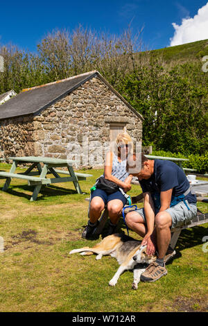 Royaume-uni, Angleterre, Cornouailles, Porthgwarra, couple avec chien dans jardin de cafe Banque D'Images