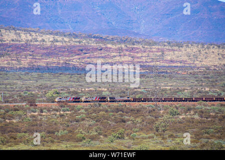 Long train au parc national de Karijini transporter le minerai de fer de Marandoo site minier vers prochain port Banque D'Images