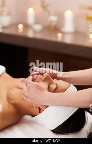 Head and shoulders portrait of Beautiful woman race mixte face massage dans un spa de luxe, copy space Banque D'Images