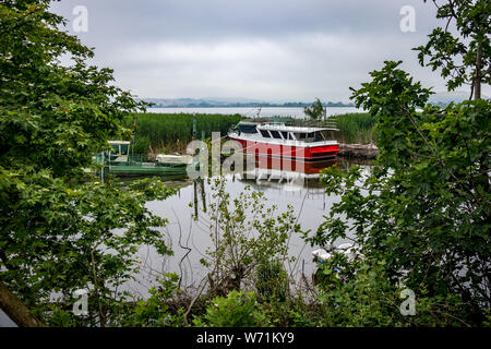 IOANNINA, GRÈCE - juin 6, 2019 - petite croisière touristique blanc et rouge et vert les bateaux de pêche sur le lac Pamvotis moore près de la belle petite de grec Banque D'Images