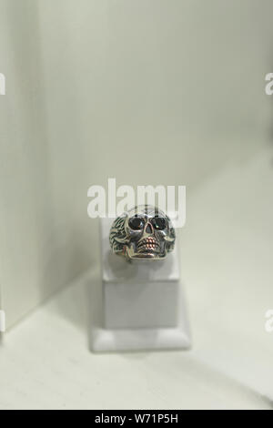 Bague argent sous la forme d'un crâne sur une voile dans un magasin. ertical photo. Banque D'Images