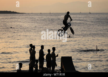 Athènes, Grèce. 3e août 2019. Les gens regardent en tant que cycliste saute dans la mer avec son vélo pendant la journée BMX Water Jump 2019 événement à plage de Kavouri à Athènes, Grèce le 3 août 2019. Le Lefteris Crédit : Partsalis/Xinhua Banque D'Images