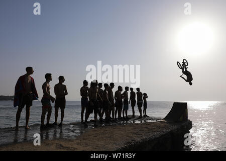 Athènes, Grèce. 3e août 2019. Les gens regardent en tant que cycliste saute dans la mer avec son vélo pendant la journée BMX Water Jump 2019 événement à plage de Kavouri à Athènes, Grèce le 3 août 2019. Le Lefteris Crédit : Partsalis/Xinhua Banque D'Images