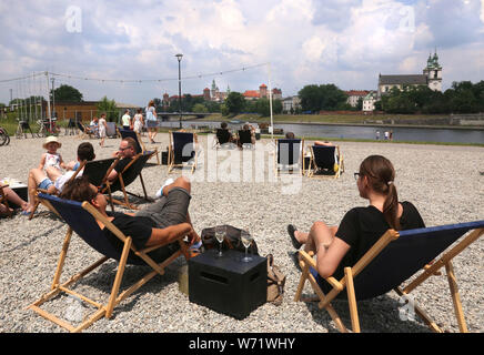 Cracovie.Pologne.Les personnes se reposant sur la plage artificielle faite pour les clients du restaurant.Château royal de Wawel en face de la rivière en arrière-plan Banque D'Images