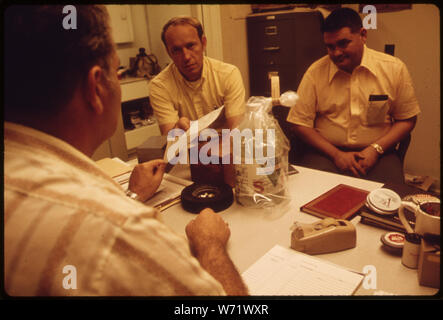 Un inspecteur de l'AGENCE DE PROTECTION DE L'ENVIRONNEMENT PESTICIDES MAINS UN REÇU POUR LES ÉCHANTILLONS PRÉLEVÉS LORS D'UNE INSPECTION DE ROUTINE À UN FONCTIONNAIRE DE L'ENTREPRISE CHIMIQUE DE LA VALLÉE (AU PREMIER PLAN), Greenville, Mississippi LE TROISIÈME HOMME EST UN INSPECTEUR DE L'EPA DANS LA FORMATION Banque D'Images