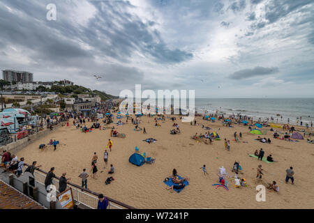 Bournemouth, Royaume-Uni. 4 août 2019. Temps couvert avec un ciel orageux n'a pas dissuader les foules de personnes bénéficiant d'Bourneomuth beach et nager dans la mer. Crédit : Thomas Faull/Alamy Live News Banque D'Images