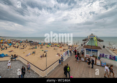 Bournemouth, Royaume-Uni. 4 août 2019. Temps couvert avec un ciel orageux n'a pas dissuader les foules de personnes bénéficiant d'Bourneomuth beach et nager dans la mer. Crédit : Thomas Faull/Alamy Live News Banque D'Images