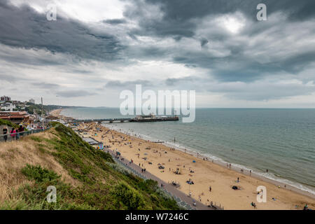 Bournemouth, Royaume-Uni. 4 août 2019. Temps couvert avec un ciel orageux n'a pas dissuader les foules de personnes bénéficiant d'Bourneomuth beach et nager dans la mer. Crédit : Thomas Faull/Alamy Live News Banque D'Images