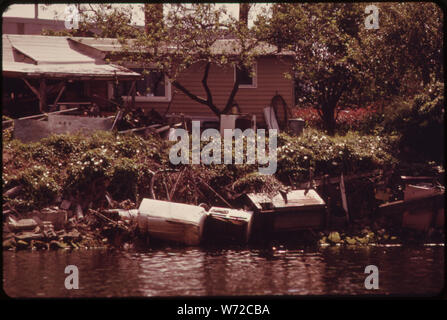 Propriétaire d'une maison SUR LA RIVIÈRE DUWAMISH UTILISE JETÉS RÉFRIGÉRATEUR Lave-linge, cuisinière et concrètes pour prévenir l'érosion de la rive du fleuve Banque D'Images