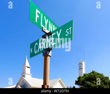 Un clocher blanc et le château d'eau Bulldogs Carney se tenir derrière la plaque de rue à l'angle de Flynn et Carney Street à Carney en Oklahoma. Banque D'Images