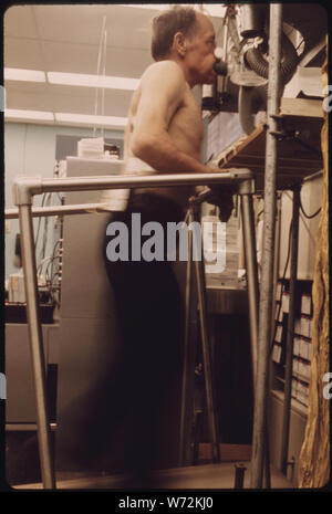 MINER EST RELIÉ À UNE MACHINE À RESPIRER POUR CONTRÔLER LA QUANTITÉ DE CAPACITÉ PULMONAIRE IL A EN MARCHANT SUR UN TAPIS ROULANT PENDANT LES ESSAIS À LA BLACK LUNG LABORATOIRE DE L'HÔPITAL RÉGIONAL DES APPALACHES À BECKLEY, WEST VIRGINIA. Des échantillons de sang sont également prises et son rythme cardiaque est surveillée. Ces ET D'AUTRES MÉTHODES D'ESSAI CONNUS SONT UTILISÉS POUR DÉTERMINER SI LES PARTICULES DE POUSSIÈRE DE CHARBON, les mineurs ont accumulé dans leurs poumons qui provoquent un essoufflement progressif Banque D'Images