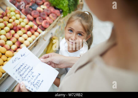 High angle portrait of cute little girl à maman en faisant vos achats chez farmers market ensemble, copy space Banque D'Images