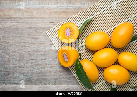 Close up jaune frais prune marian (Mayongchid in Thai nom) sur table en bois Banque D'Images