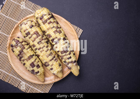 Jaune frais Maïs doux en épis. Studio shot sur pierre noire de fond du Conseil. Pour l'alimentation concept. Vue d'en haut Banque D'Images