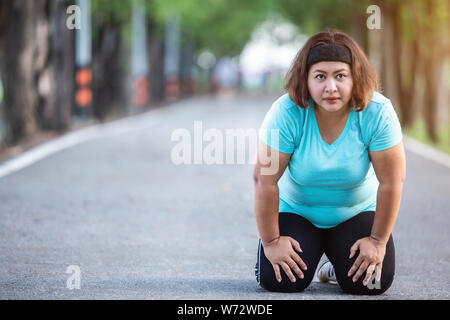 L'exercice et une saine concept : grosse femme sensation de fatigue lors de l'exécution dans le parc Banque D'Images