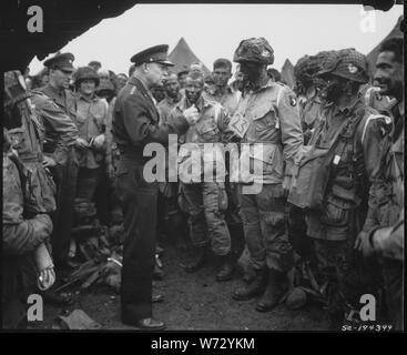 Photographie du général Dwight D. Eisenhower rencontre les troupes avant l'invasion de Normandie ; Portée et contenu : la légende originale : le général Dwight D. Eisenhower répond aux parachutistes américains en Angleterre, juste avant qu'ils bord de leurs avions pour participer à la première agression dans l'invasion du continent de l'Europe, l'invasion de Normandie. Banque D'Images