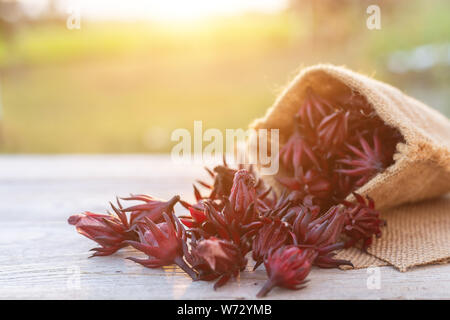 Pile de Roselle rouge frais sur table en bois avec fond coucher de soleil Banque D'Images