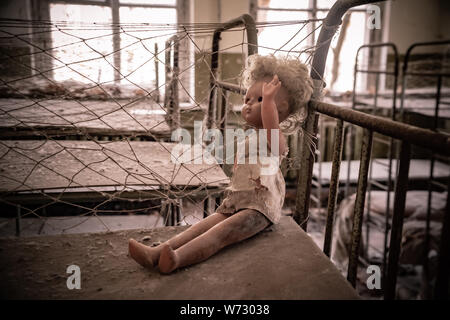 Broken doll dans Kopachi maternelles, zone d'aliénation de Tchernobyl l'Ukraine Banque D'Images