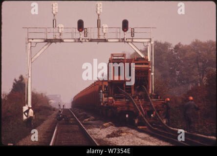 Le sud de l'EMPRISE DU CHEMIN DE FER DE L'ÉQUIPE DE TRAVAIL, AVEC UNE VOITURE QUI EST TITULAIRE D'nouveau quart de mile de longues SECTIONS DE RAIL QUI REMPLACERA L'ancienne piste. L'ENTREPRISE EN 1974 A EU UNE MOYENNE DE QUATRE ÉQUIPAGES au nombre de 50 à 55 hommes chacune TRAVAILLE SUR LE SYSTÈME EST 10 531 milles de voie de chemin de fer. Vitesse maximale SÉCURITAIRE SUR PRATIQUEMENT TOUTES LES PISTES DU SUD EST DE 60 MILLES À L'HEURE. Une autre compagnie de chemin de fer A QUELQUES PISTES QUI ONT UNE LIMITE DE VITESSE DE 13 kilomètres par heure Banque D'Images