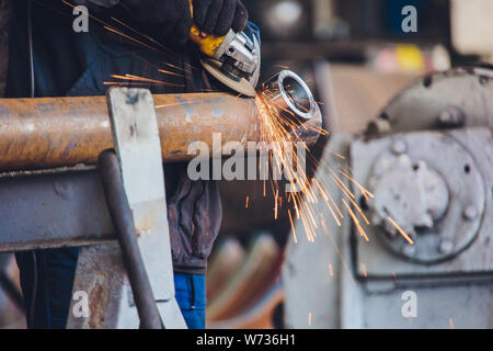 Des travailleurs dans une fonderie moulages grind avec une meuleuse - milieu de l'industrie lourde. Banque D'Images