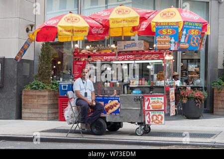 Un vendeur de hot dog vente alimentaire, bretzels, sodas, etc. juste à côté de la Cinquième Avenue à Manhattan, Midtown, USA. Banque D'Images