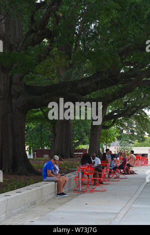 Les visiteurs s'asseoir sous l'ombre des vieux arbres dans le Square revitalisé Moore (2019) au centre-ville de Raleigh en Caroline du Nord. Banque D'Images