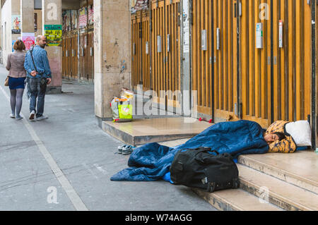 Les gens passent par un jeune homme endormi dans la rue à Paris. Le problème des réfugiés et des migrants en Europe. Paris, France, Octobre 04, 2014. Banque D'Images