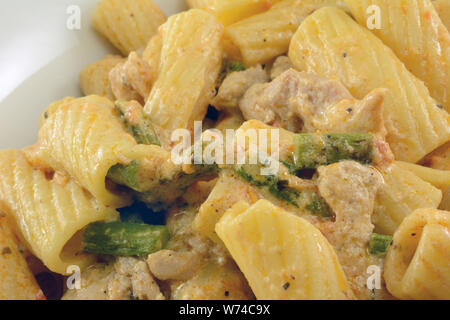 Pâtes Rigatoni avec poulet et sauce à la crème d'asperges dans un plat blanc Banque D'Images