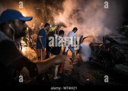 Le Caire, Égypte. Le 05 août, 2019. Les gens éteindre un incendie après une explosion en face de l'Institut National du Cancer. Selon le ministère de la santé, au moins 17 personnes sont mortes et 26 blessées. Credit : Oliver Weiken/dpa/Alamy Live News Banque D'Images