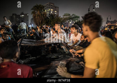 Le Caire, Égypte. Le 05 août, 2019. Les gens se rassemblent à Burnt voiture en face de l'Institut national du cancer après une explosion. Selon le ministère de la santé, au moins 17 personnes sont mortes et 26 blessées. Credit : Oliver Weiken/dpa/Alamy Live News Banque D'Images