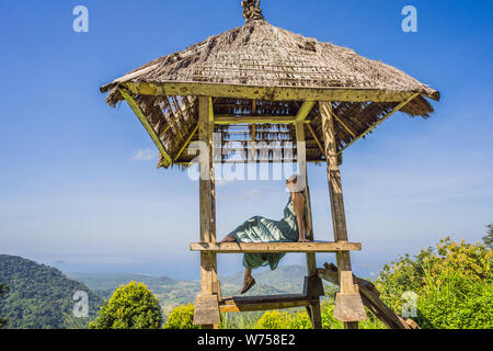 Jeune femme en Gazebo balinais traditionnels. L'île de Bali Banque D'Images