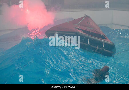 Enge Sande, Allemagne. 19 juillet, 2019. Dans un radeau pendant les tempêtes et l'obscurité, les techniciens à l'étranger former comment survivre en mer dans le centre de formation maritime Offtec. L'entraînement de survie fait partie de la programme obligatoire pour les techniciens sur les éoliennes. Crédit : Carsten Rehder/dpa/Alamy Live News Banque D'Images