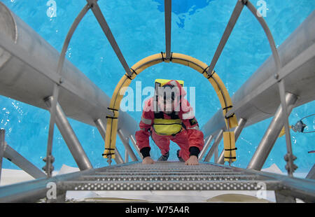 Enge Sande, Allemagne. 19 juillet, 2019. Henning Tillmanns, technicien, grimpe une échelle à Offtec maritime du centre de formation. L'entraînement de survie fait partie de la programme obligatoire pour les techniciens sur les éoliennes. Crédit : Carsten Rehder/dpa/Alamy Live News Banque D'Images