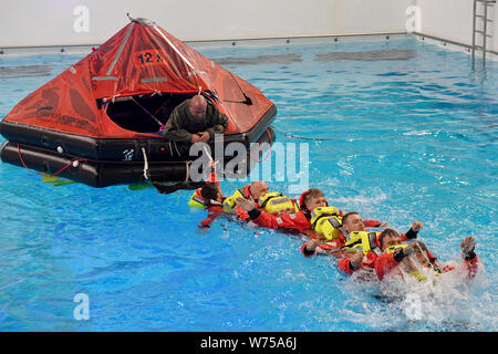 Enge Sande, Allemagne. 19 juillet, 2019. Sous la direction du professeur René (Ploegert dans le radeau de survie), les techniciens à l'étranger former comment survivre en mer dans le centre de formation maritime Offtec. L'entraînement de survie fait partie de la programme obligatoire pour les techniciens sur les éoliennes. (Dpa 'pas d'emploi pour "Wimp" : technicien de service sur les installations offshore') Crédit : Carsten Rehder/dpa/Alamy Live News Banque D'Images