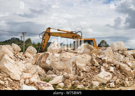 Le tracteur sur de gros des pierres sur les montagnes avec de la pelouse et des arbres paysage avec belle journée Banque D'Images