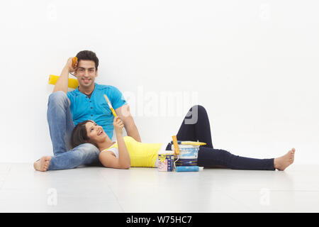 Young couple taking a break while painting their home Stock Photo