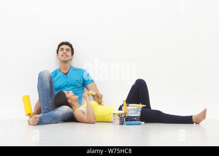 Young couple taking a break while painting their home Stock Photo