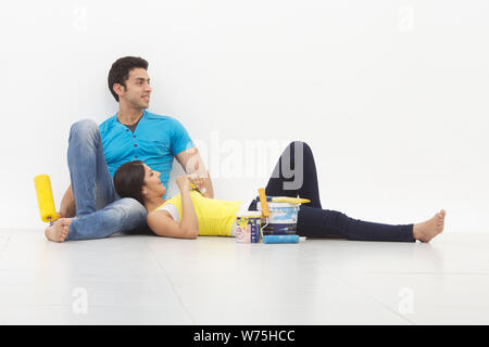 Young couple taking a break while painting their home Stock Photo