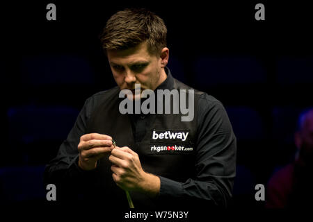 Ryan Jour de galles les craies son cue qu'il estime un shot à Li Hang de Chine dans leur quatrième match au cours de la 2017 Championnat du Royaume-Uni Betway snooker Banque D'Images