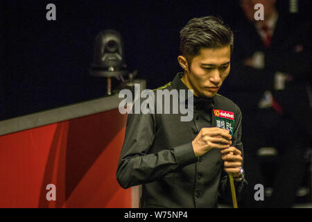 Yupeng Cao de Chine les craies son cue qu'il estime un shot de Ricky Walden de l'Angleterre dans leur quart de finale lors de l'Ope écossais 2017 Dafabet Banque D'Images